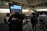 Journalists film an electronic stock board showing reopened Japan's Nikkei 225 index at Tokyo Stock Exchange in Tokyo Friday, Oct. 2, 2020. Tokyo's market resumed trading Friday after a full-day outage due to a malfunction in its computer systems. (AP Photo/Eugene Hoshiko)