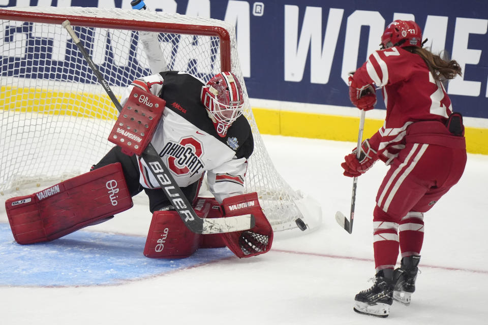 Ohio State goaltender Raygan Kirk (1) deflects the puck as Wisconsin forward Kirsten Simms (27) is unable to score in the second period of an NCAA college women's championship hockey game, Sunday, March 24, 2024, in Durham, N.H. (AP Photo/Steven Senne)