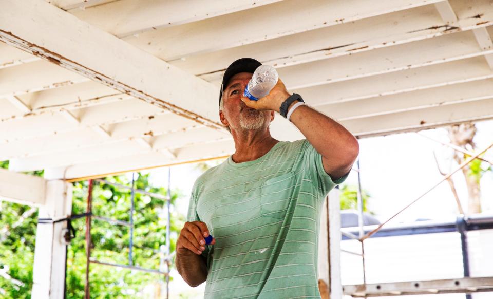 Rick Borman hydrates on a hot afternoon on Fort Myers Beach on July, 24. He was repairing his Hurricane Ian damaged home.