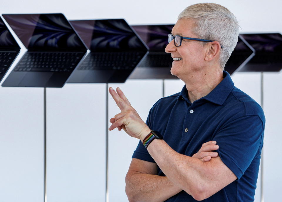 Apple CEO Tim Cook poses in front of a new MacBook Airs running M2 chips display during Apple's annual Worldwide Developers Conference in San Jose, California, U.S. June 6, 2022. REUTERS/Peter DaSilva