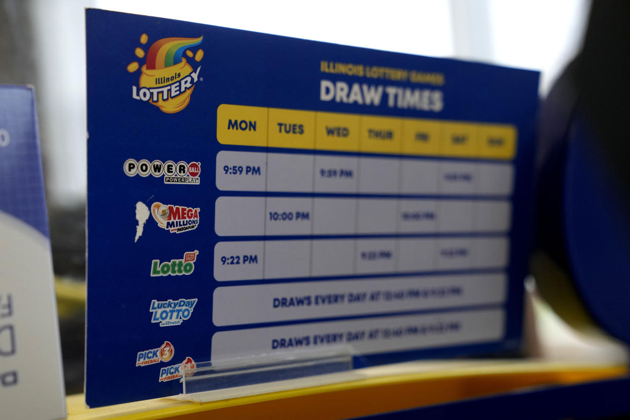 A Illinois Lottery games draw time schedule is displayed included Mega Millions at a convenience store Tuesday, Jan. 3, 2023, in Northbrook, Ill. (AP Photo/Nam Y. Huh)
