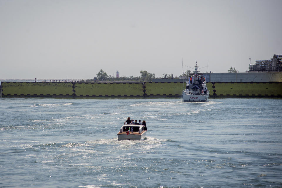 Moveable flood gates rise from the sea in the Venice lagoon, Italy, Friday, July 10, 2020. Venice has conducted a trial run an ambitious anti-flood system of 78 inflatable barriers in the hopes of protecting the lagoon city from devastating high tides. Premier Giuseppe Conte on Friday at a ceremony in Venice pressed a button that activated compressors to pump air into the bright yellow barriers, which then started rising from the sea to act a kind of a dike-on-demand. (Claudio Furlan/LaPresse via AP)