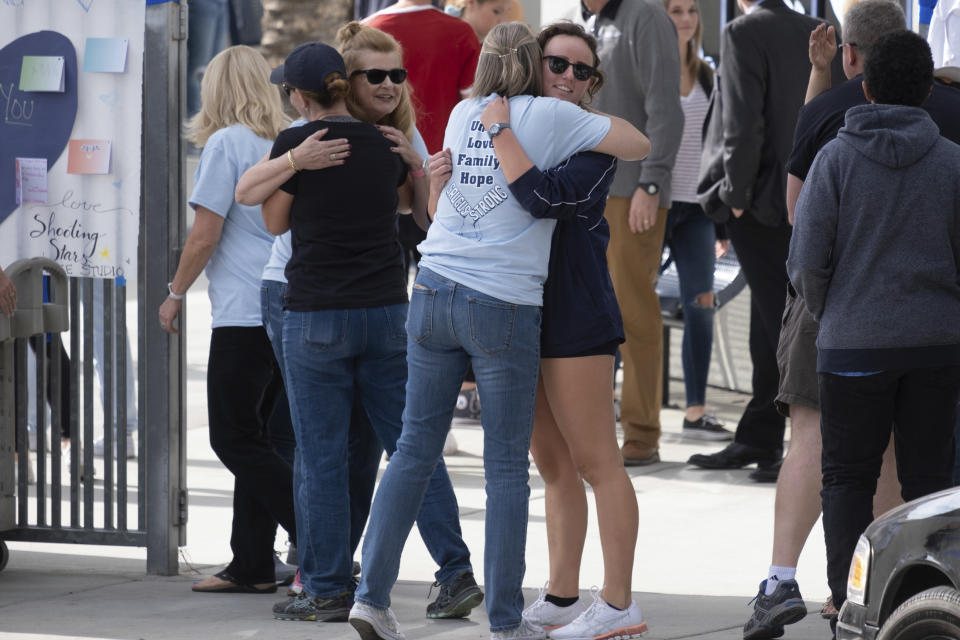 Saugus students hug as they arrive at Saugus High Tuesday, Nov. 19, 2019. Students were allowed back to collect their belongings left behind after the tragic shooting last Thursday. Classes will resume at the high school on Dec. 2. (David Crane/The Orange County Register via AP)