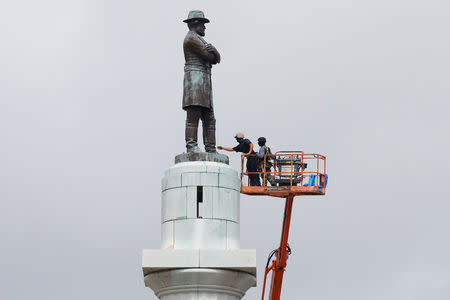 Construction crews prepare a monument of Robert E. Lee, who was a general in the Confederate Army, for removal in New Orleans, Louisiana, U.S., May 19, 2017. REUTERS/Jonathan Bachman