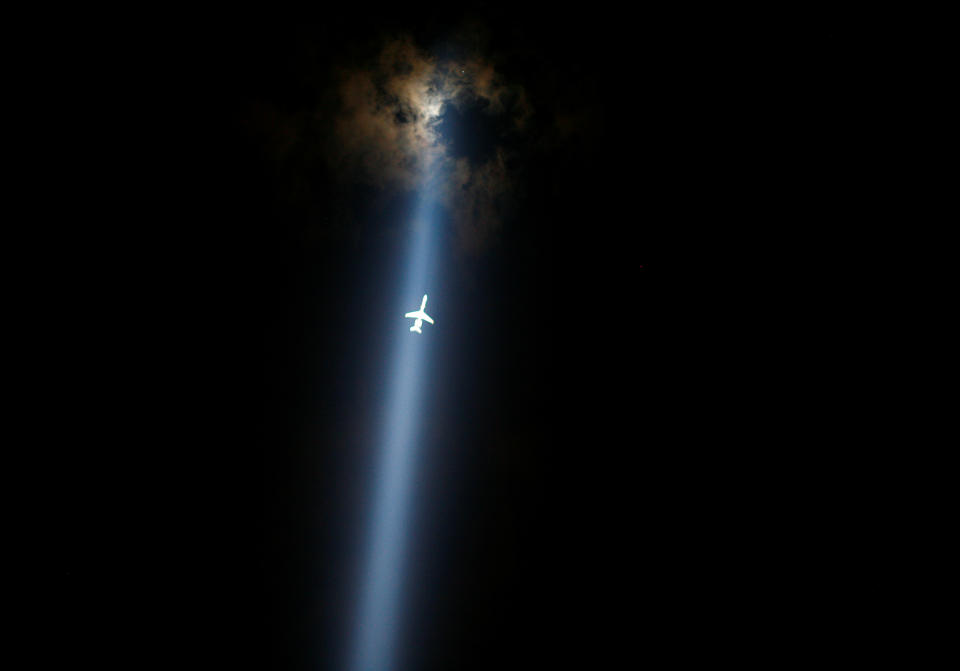 A plane flies through the "Tribute in Lights" marking the 10th anniversary of the 9/11 attacks in lower Manhattan, New York, U.S., September 10, 2011.