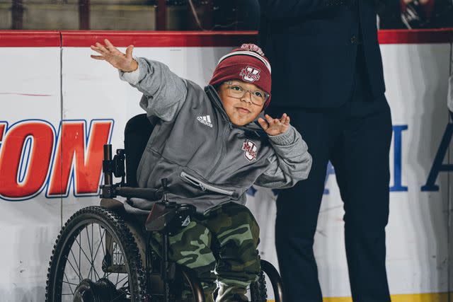 <p>Team IMPACT</p> Adrian Diaz cheering his UMass Hockey Team