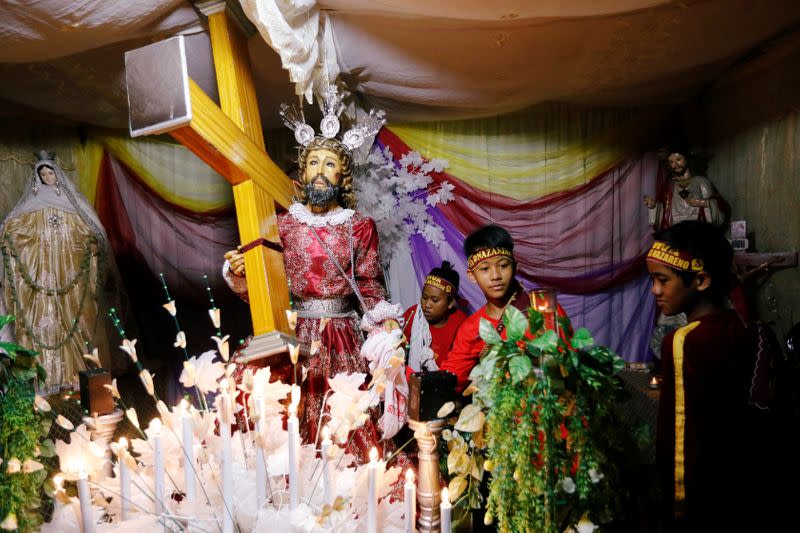 Youth devotees prepare a replica of Black Nazarene statue as they take part in the annual procession to celebrate a feast day at a main road in Manila