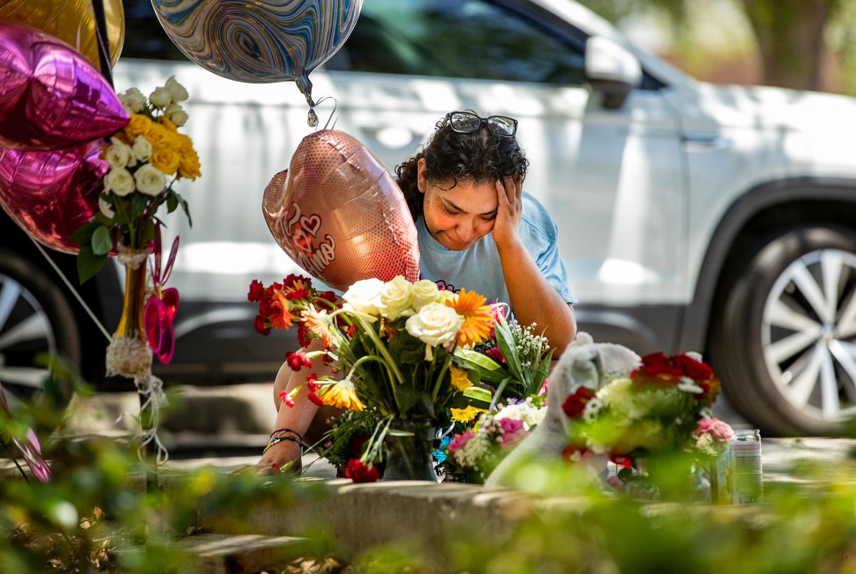 Esmeralda Pocopa sits and cries at a makeshift memorial for her sister Yahorany "Nani" Popoca, at the site where she was fatally shot Sunday morning outside La Fiesta Mexicana Restaurant in Haines City. Nani's estranged boyfriend, Rolando Guevara Zarate, is accused of her murder. Family members say Guevara had repeatedly stalked and threatened Popoca, despite successive restraining orders.