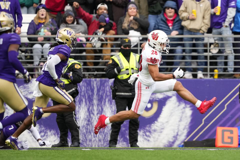 Utah running back Sione Vaki, right, scores a touchdown in front of Washington safety Vincent Nunley during the first half of an NCAA college football game Saturday, Nov. 11, 2023, in Seattle. | Lindsey Wasson, Associated Press