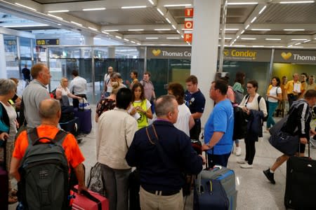 Passengers are seen at Thomas Cook check-in points at Mallorca Airport as an announcement is expected on the tour operator, in Palma de Mallorca