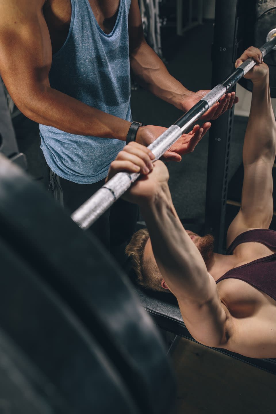 two friends exercising bench press in gym