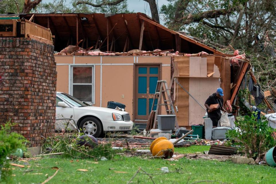 A woman salvages personal belongings from a damaged home in Moss Point on Tuesday, June 20, 2023, after a tornado tore through the town on Monday.