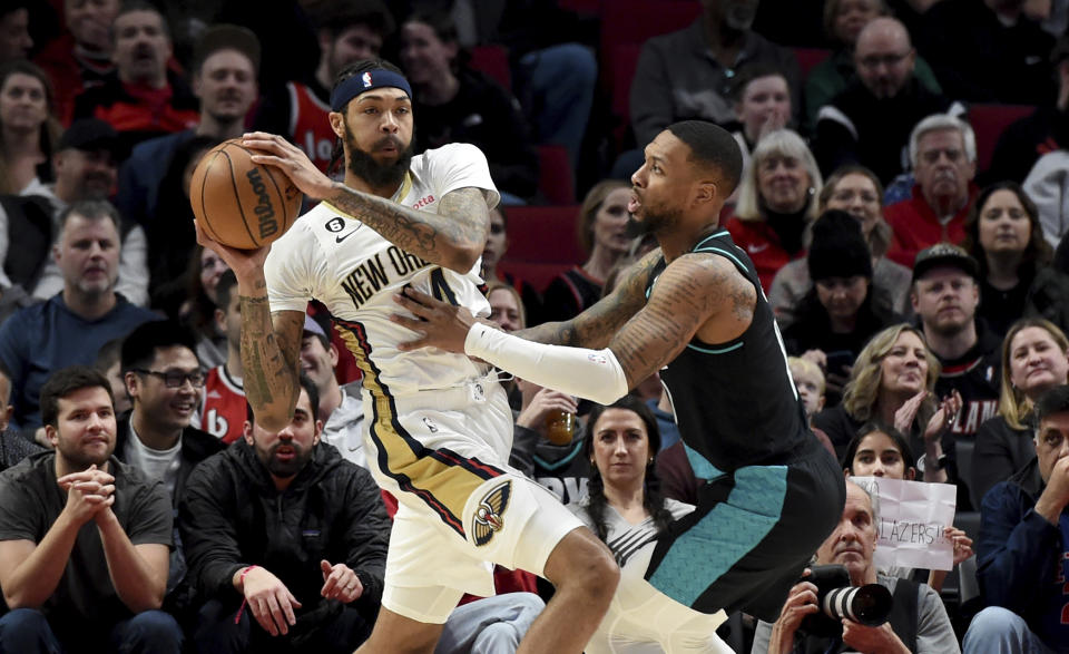 New Orleans Pelicans forward Brandon Ingram, left, looks to pass the ball as Portland Trail Blazers guard Damian Lillard defends during the first half of an NBA basketball game in Portland, Ore., Wednesday, March 1, 2023. (AP Photo/Steve Dykes)