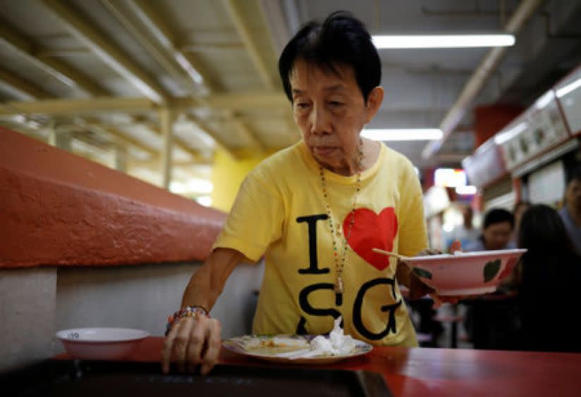 Cleaner Mary Lim, 71, clears tables at a food centre in Singapore, December 13, 2018. (Photo: REUTERS/Edgar Su)