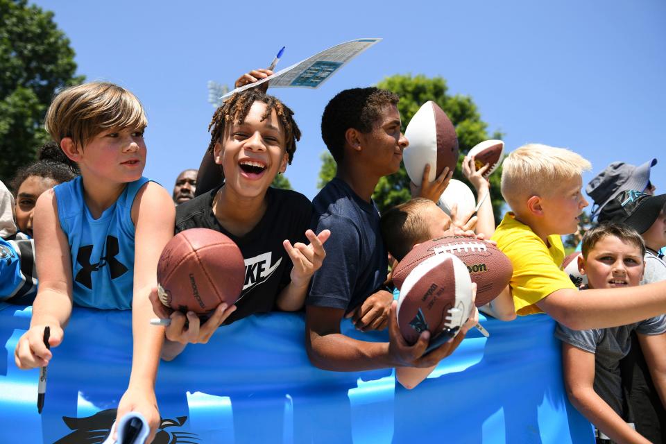 Young kids hold their memorabilia to be autographed during the 2023 Carolina Panthers Training Camp at Wofford College in Spartanburg, S.C., on Wednesday, July 26, 2023.