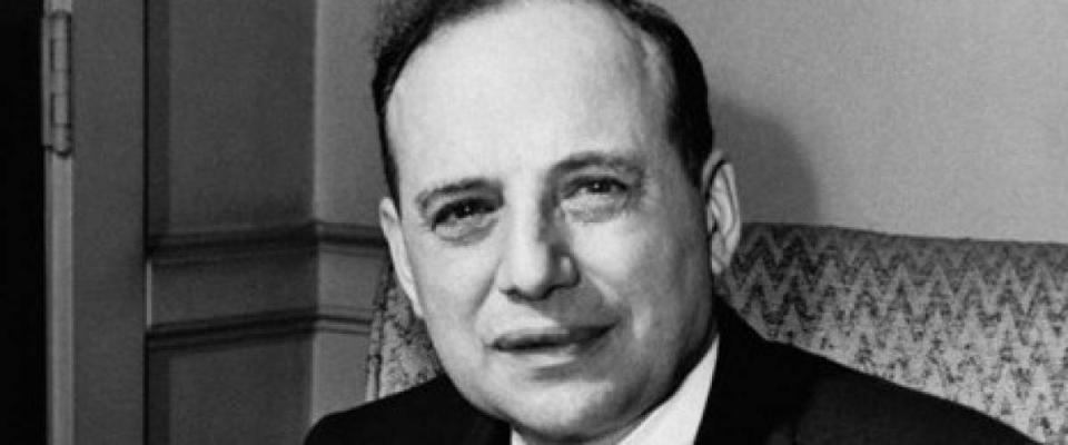 Benjamin Graham sits and looks up at the camera.