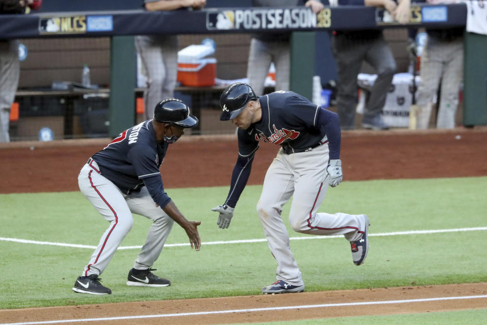 Atlanta Braves first baseman Freddie Freeman celebrates his two-run home run with third base coach Ron Washington against the Los Angeles Dodgers during the fourth inning in Game 2 Tuesday, Oct. 13, 2020, in the best-of-seven National League Championship Series at Globe Life Field in Arlington, Texas. (Curtis Compton/Atlanta Journal-Constitution via AP)