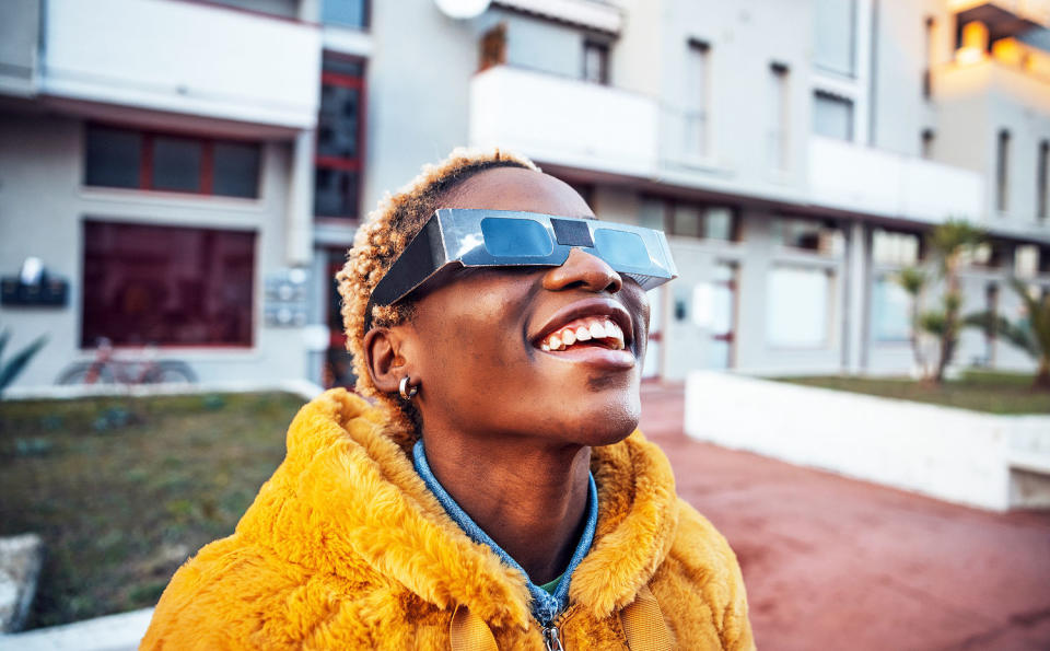 Teenage girl looking at solar eclipse with glasses (Leo Patrizi / Getty Images)