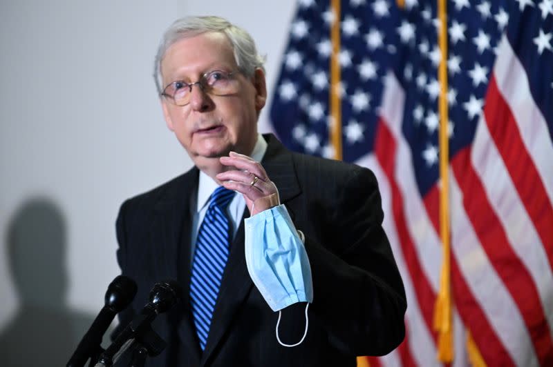 FILE PHOTO: Senate Majority Leader McConnell holds a face mask while participating in a news conference at the U.S. Capitol in Washington