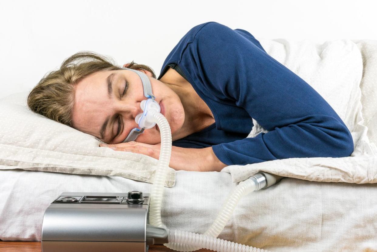 Woman sleeping on her side with CPAP machine.