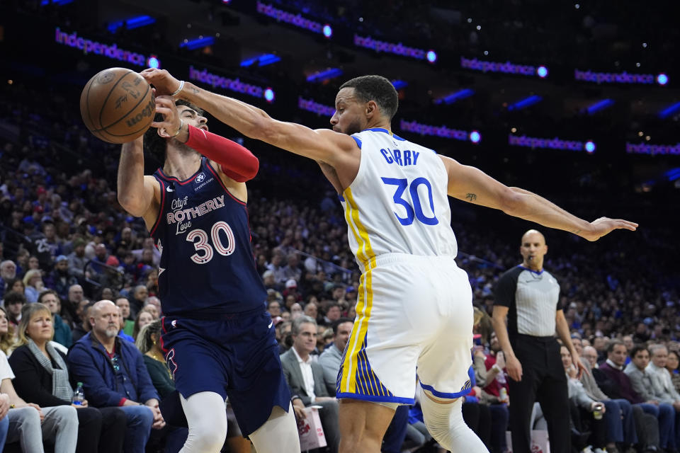 Philadelphia 76ers' Furkan Korkmaz, left, cannot hang onto the ball against Golden State Warriors' Stephen Curry during the first half of an NBA basketball game, Wednesday, Feb. 7, 2024, in Philadelphia. (AP Photo/Matt Slocum)