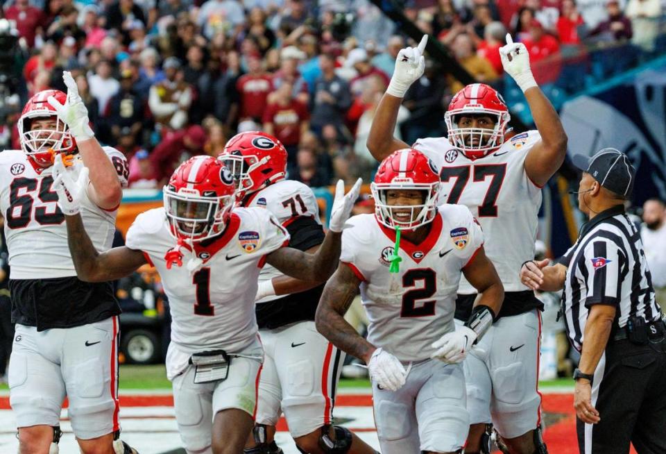 Georgia Bulldogs running back Kendall Milton (2) celebrates with teammates after scoring a touchdown against the Florida State Seminoles during the second half of the 90th annual Capital One Orange Bowl at Hard Rock Stadium on Saturday, Dec. 30, 2023 in Miami Gardens, Fla.