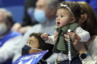 Seven month old Scotland Smith, right, and her cousin Ross Smith cheer for their grandfather, High Point head coach Tubby Smith and his team during the second half of an NCAA college basketball game between High Point and Kentucky in Lexington, Ky., Friday, Dec. 31, 2021. Kentucky won 92-48. Before the game Smith was honored with a jersey retirement. (AP Photo/James Crisp)