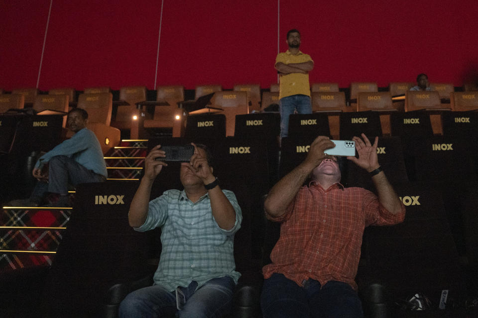 Journalists record with their cellphone as engineers play a trailer of a Bollywood movie to check for sound and picture quality ahead of the inauguration of 'INOX' multiplex in Srinagar, Indian controlled Kashmir, Monday, Sept. 19, 2022. The multi-screen cinema hall has opened in the main city of Indian-controlled Kashmir for public for the first time in 14 years. The 520-seat hall with three screens opened on Saturday, Oct. 1, amid elaborate security but only about a dozen viewers lined up for the first morning show. (AP Photo/Dar Yasin)