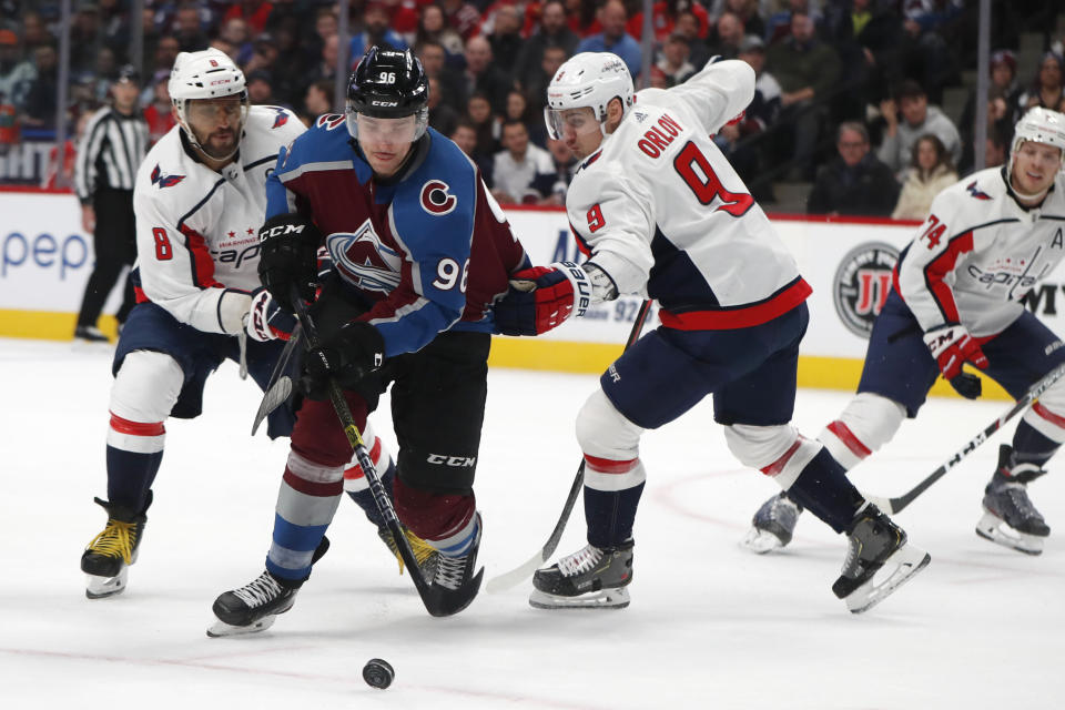 Colorado Avalanche right wing Mikko Rantanen, center, drives between Washington Capitals left wing Alex Ovechkin, left, and defenseman Dmitry Orlov in the first period of an NHL hockey game Thursday, Feb. 13, 2020, in Denver. (AP Photo/David Zalubowski)