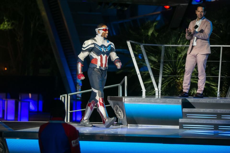 An actor dressed as Captain America takes the stage as Paul Rudd applauds.