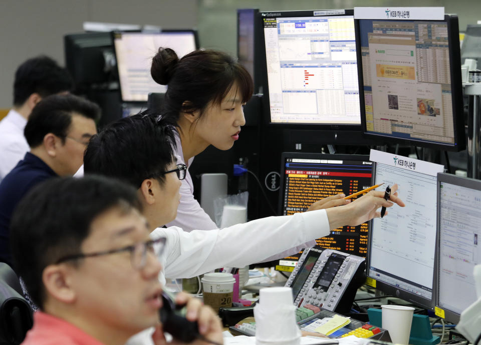 Currency traders watch monitors at the foreign exchange dealing room of the KEB Hana Bank headquarters in Seoul, South Korea, Friday, June 28, 2019. Asian stocks sank Friday as investors waited for a meeting between Presidents Donald Trump and Xi Jinping that they hope will produce a truce in spiraling U.S.-China trade tensions. (AP Photo/Ahn Young-joon)