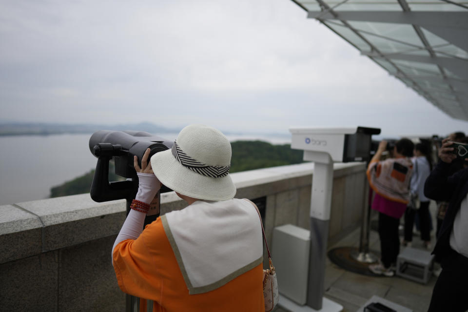 Visitors use binoculars to see the North Korean side from the unification observatory in Paju, South Korea, Thursday, May 30, 2024. North Korea on Thursday fired a barrage of suspected ballistic missiles toward its eastern sea, according to South Korea's military, days after its attempt to launch a military reconnaissance satellite ended in failure but still drew strong condemnation from its rivals. (AP Photo/Lee Jin-man)