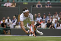 Taylor Fritz of the US dives to make a return to Australia's Jason Kubler in a men's singles fourth round match on day eight of the Wimbledon tennis championships in London, Monday, July 4, 2022. (AP Photo/Alastair Grant)