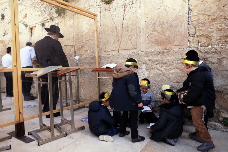 Ultra-Orthodox Jewish boys play as men pray in front of the Western Wall, Judaism's holiest prayer site, in Jerusalem's Old City