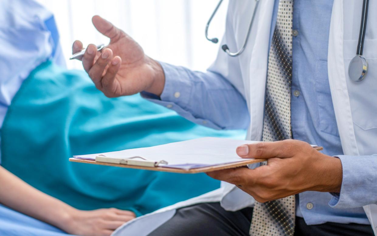 A stock photo shows a doctor with a patient