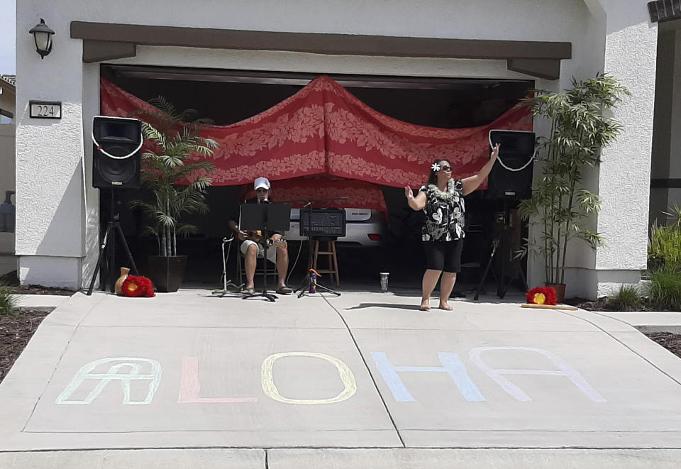 Lisa and Larry Neula perform Hawaiian dance and music for neighbors in Sacramento, Calif., in April 2020. (Lenore Kostelnick via AP)