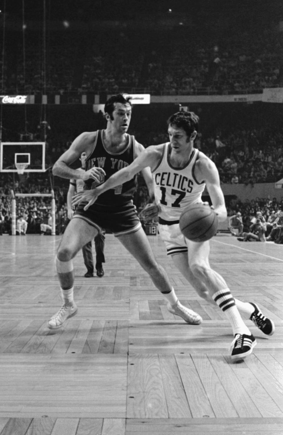 FILE - In this Thursday, April 13, 1972 file photo, Boston Celtics' John Havlicek (17) dribbles ball around New York Knicks' Bill Bradley during an NBA basketball game in Boston. The Boston Celtics say Hall of Famer John Havlicek, whose steal of Hal Green’s inbounds pass in the final seconds of the 1965 Eastern Conference finals against the Philadelphia 76ers remains one of the most famous plays in NBA history, has died. The team says Havlicek died Thursday, April 25, 2019 at age 79. (AP Photo/File)