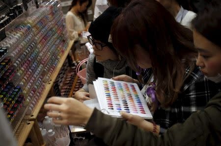 Shoppers look at various colors of manicure displayed at an exhibition and sale during Tokyo Nail Expo 2015 in Tokyo, Japan, November 15, 2015. REUTERS/Yuya Shino