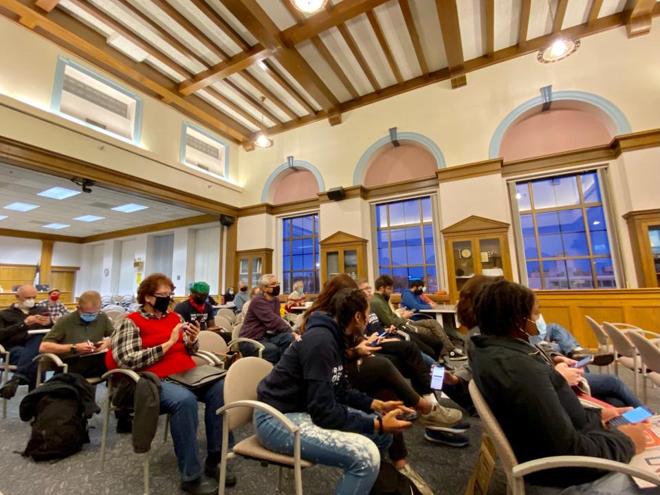 Ames community members answer surveys on their phones during the city’s Climate Action Plan Town Hall Meeting at City Hall on October 25, 2021.