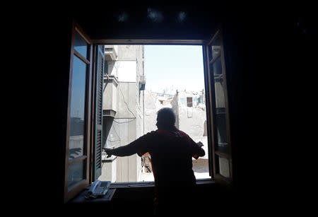 Hisham Abu al-Ela, a 55-year-old businessman, close the window of his house which hasn't been demolished yet, in the so-called "Maspero Triangle", in Cairo, Egypt, September 13, 2018. REUTERS/Amr Abdallah Dalsh