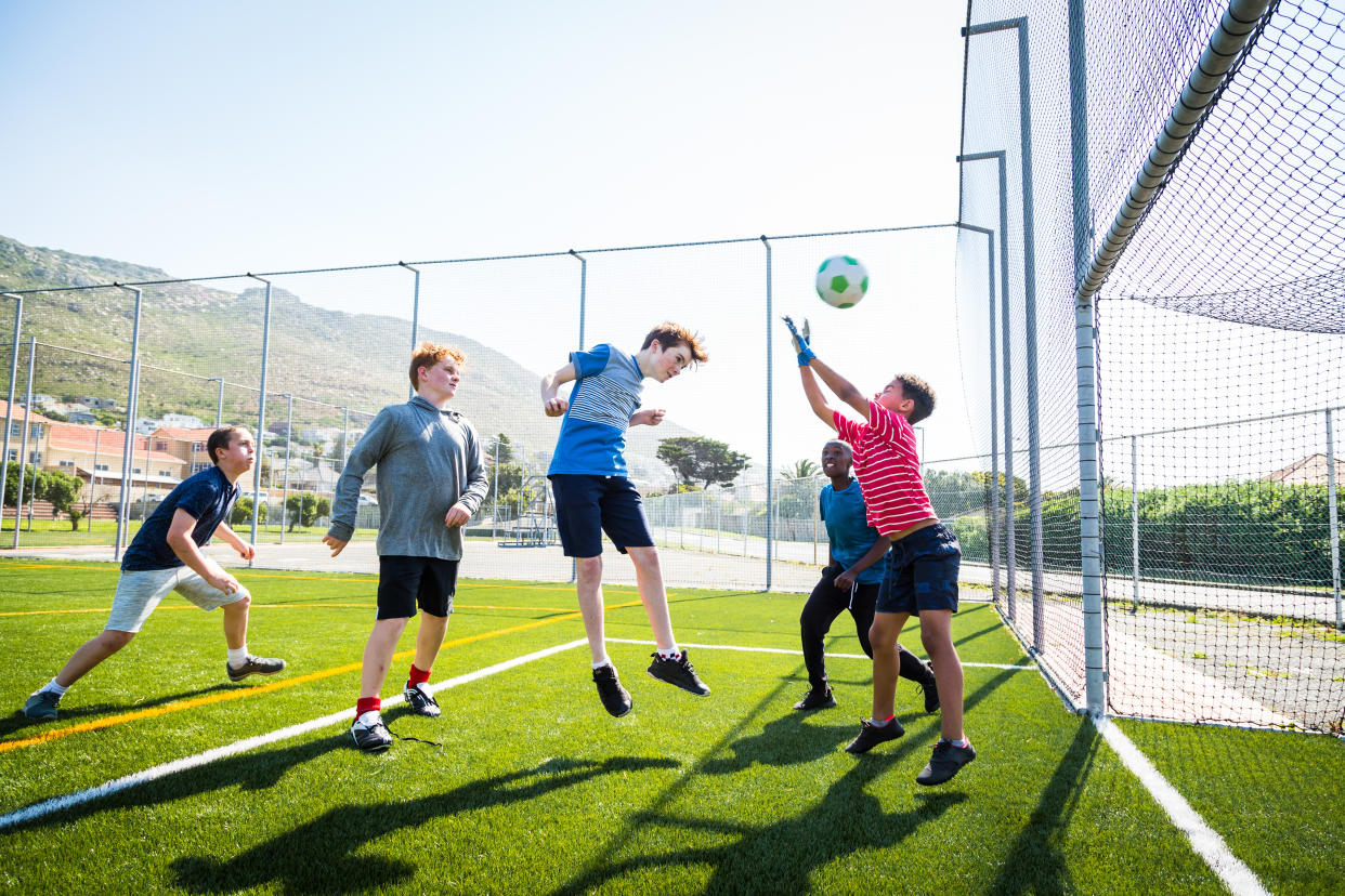 Boy heading a goal on a soccer pitch exercise