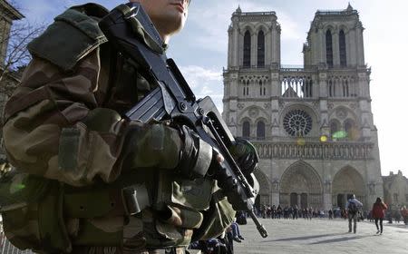 An armed French soldier patrols in front of Notre Dame Cathedral in Paris, France, December 24, 2015. REUTERS/Philippe Wojazer/File Photo