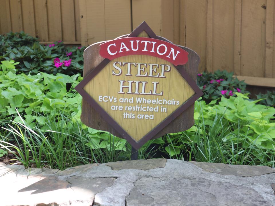 A sign at Dollywood reading "Caution: steep hill."