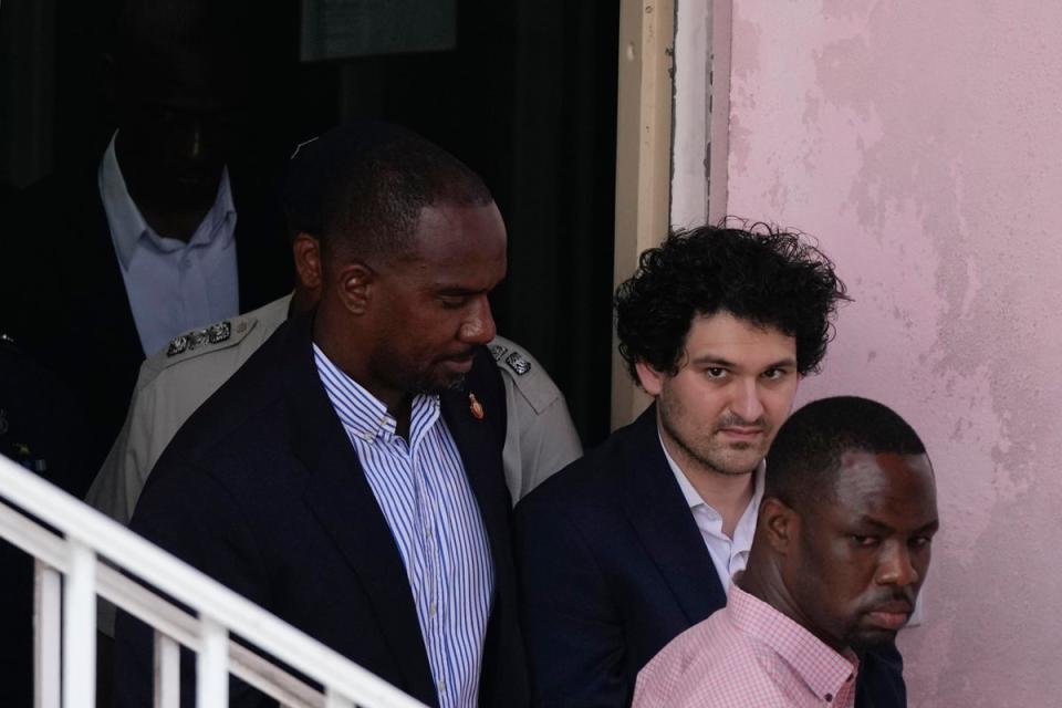 FTX founder Sam Bankman-Fried, second right, is escorted out of Magistrate Court in the Bahamas following his arrest in late 2022 (Associated Press)