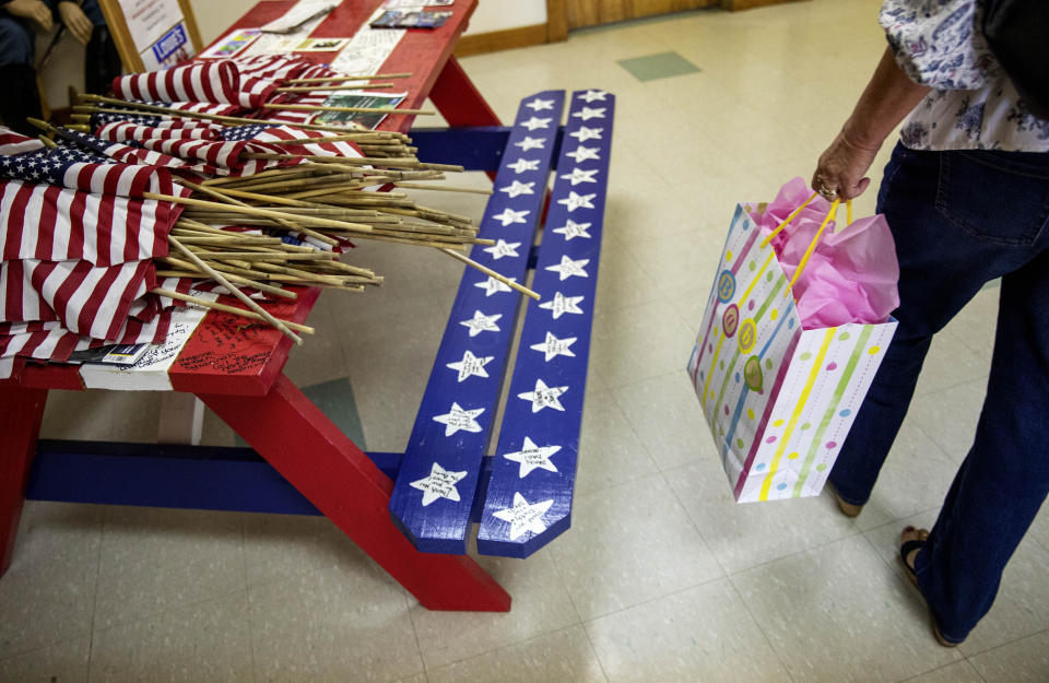 Guests carrying gifts arrive for a baby shower for Krista Johnston at the American Legion hall in Trumansburg, N.Y., Sunday, Sept. 1, 2019. Krista's husband, Sgt. James Johnston, was killed in Afghanistan in June just months after learning he would become a father. The hall had been transformed for a baby shower with towering piles of gifts amid pink and blue balloons where just the day before is hosted a memorial for Johnston among patriotic displays of red, white and blue. (AP Photo/David Goldman)