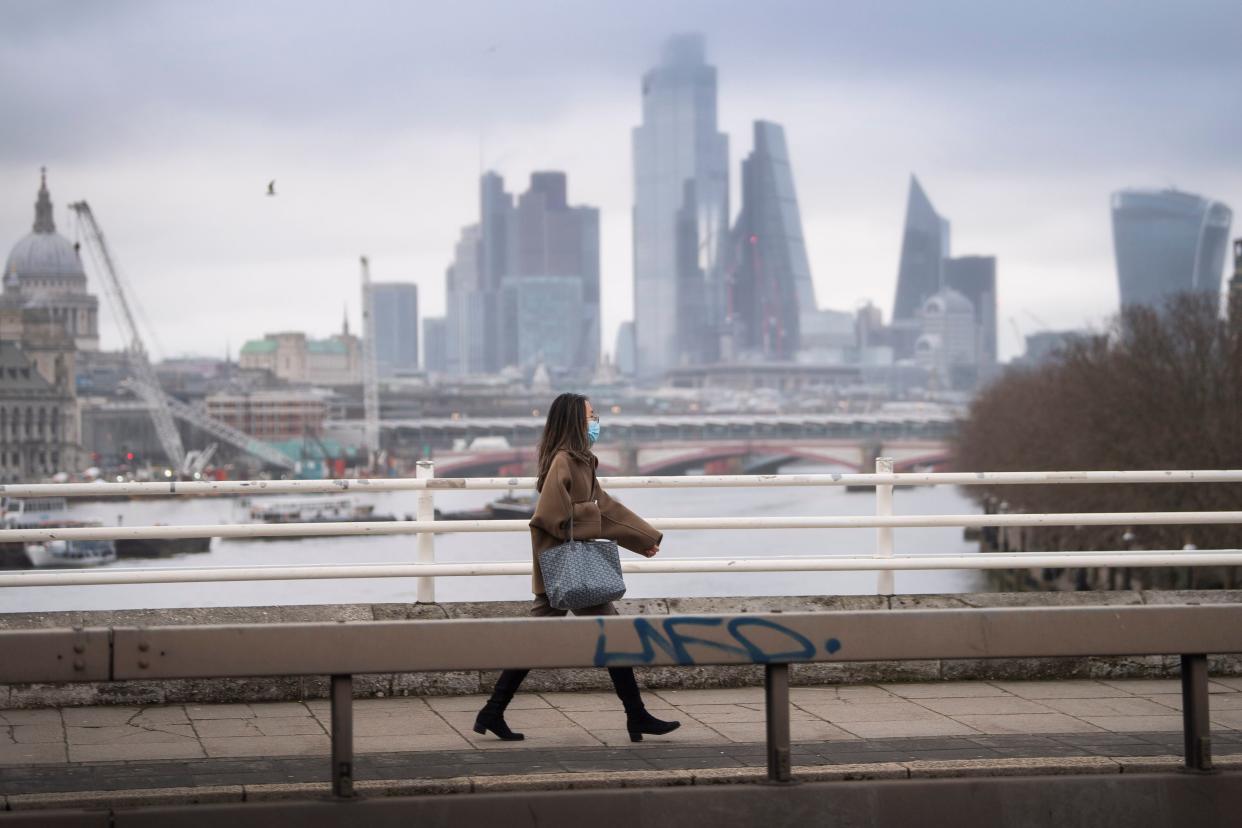 <p>A woman walks across Waterloo Bridge during England’s third national lockdown</p> (PA)