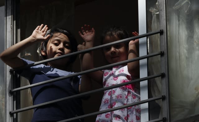 Residents wave from an apartment as Percibald Garcia reads children’s books aloud outside the high-rise buildings in the Tlatelolco housing complex in Mexico City