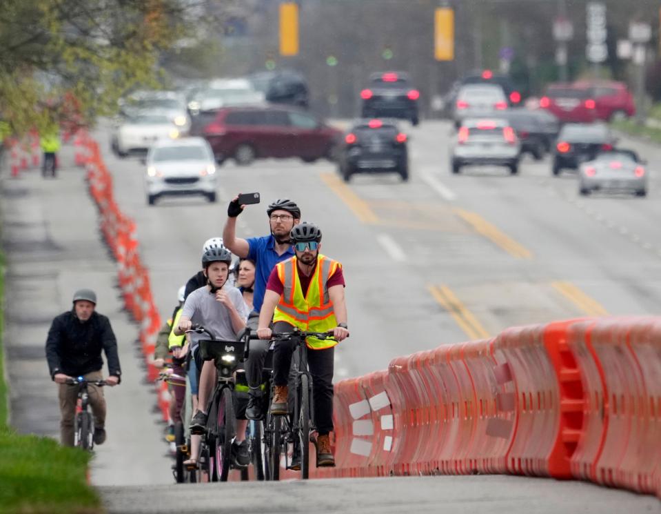 A group of cyclists travels along East Broad Street Wednesday afternoon testing a quick-build, two-way separated bike lane the city Department of Public Service erected along Franklin Park West and the entrance to Wolfe Park.