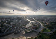 <p>Hot air balloons take to the skies as they participate in the mass assent at sunrise on the second day of the Bristol International Balloon Fiesta on August 11, 2017 in Bristol, England. (Photo: Matt Cardy/Getty Images) </p>