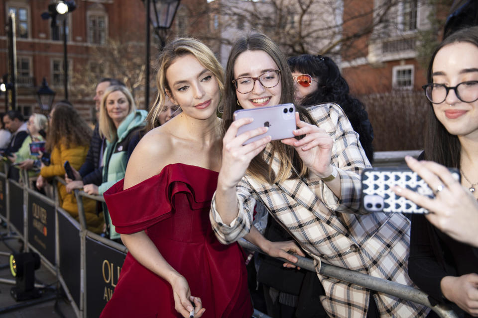 Jodie Comer poses for selfies with fans upon arrival at the Olivier Awards in London, Sunday, April 2, 2023. (Photo by Vianney Le Caer/Invision/AP)